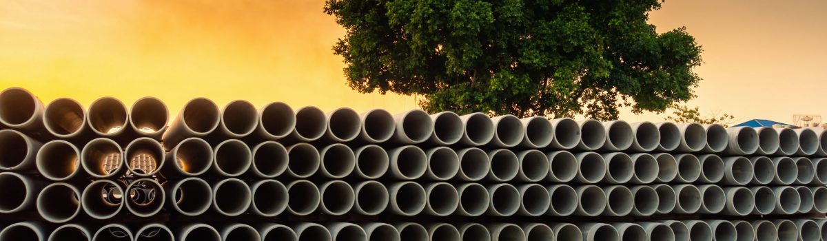 Row of Storage Sewage Drainage Concrete Pipeline, Manufacturing Plant of Material Construction, Stack of Culvert Pipe and Water Treatment System.