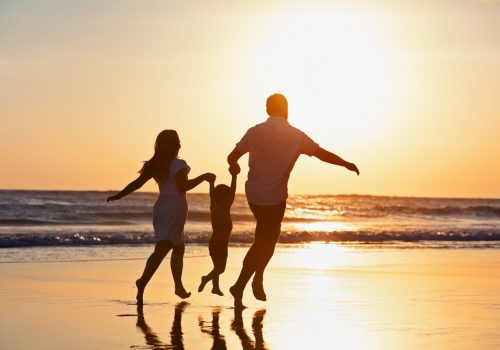 Happy family black silhouette on sun background. Father, mother, baby son run. Child jump with fun by water pool along sea surf on beach. Travel lifestyle, parents walking with kid on summer vacation.